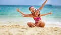 Happy family mother and chid daughter in masks on beach in summer Royalty Free Stock Photo