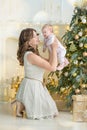 Happy family mother and child baby boy on Christmas morning at the tree with gifts, home decoration, interior house Royalty Free Stock Photo