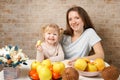 Happy family mother and child baby daughter with healthy food fruits on the kitchen Royalty Free Stock Photo