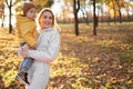 Happy family mother and child boy on a walk in the autumn leaf fall in park Royalty Free Stock Photo