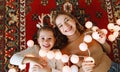 Happy family mother and child daughter with Christmas garland
