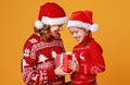 Happy family mother and child daughter  with christmas gifts on yellow background Royalty Free Stock Photo