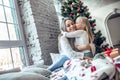 Happy family mother and child daughter on Christmas morning at the Christmas tree with gifts Royalty Free Stock Photo