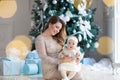 Happy family mother and child daughter on Christmas morning at the Christmas tree with gifts Royalty Free Stock Photo