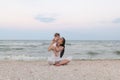 Happy family mother and child daughter doing yoga, meditate in lotus position on beach at sunset Royalty Free Stock Photo