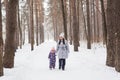 Happy family mother and child daughter having fun, playing at winter walk outdoors Royalty Free Stock Photo