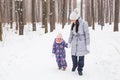 Happy family mother and child daughter having fun, playing at winter walk outdoors Royalty Free Stock Photo