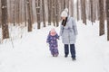 Happy family mother and child daughter having fun, playing at winter walk outdoors Royalty Free Stock Photo