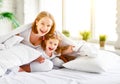 Happy family mother and child daughter laugh in bed Royalty Free Stock Photo