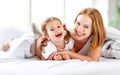 Happy family mother and child daughter laugh in bed Royalty Free Stock Photo