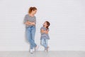 Happy family mother and child daughter near an empty wall Royalty Free Stock Photo