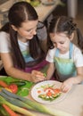 Happy family mother and child girl are preparing healthy food, they improvise together in the kitchen Royalty Free Stock Photo