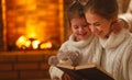 Happy family mother and child daughter read a book on winter ev Royalty Free Stock Photo