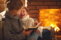 happy family mother and child daughter read book on winter evening near fireplace Royalty Free Stock Photo