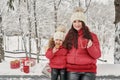 Happy family mother and child daughter on winter walk outdoors drinking tea. happy family mother and baby little child playing in Royalty Free Stock Photo