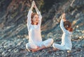 Happy family mother and child doing yoga, meditate in lotus position on beach Royalty Free Stock Photo