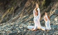 Happy family mother and child doing yoga, meditate in lotus position on beach Royalty Free Stock Photo