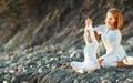 Happy family mother and child doing yoga, meditate in lotus position on beach Royalty Free Stock Photo