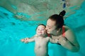 Happy Family: A mother and a child with Down syndrome enjoy swimming underwater in a turquoise water pool. The woman Royalty Free Stock Photo