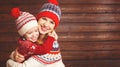 happy family mother and child girl with christmas hat hugs at wooden Royalty Free Stock Photo