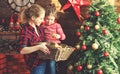 Happy family mother and child girl decorated Christmas tree