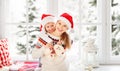 Happy family mother and child girl hugs at window at the winter Royalty Free Stock Photo