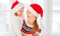 Happy family mother and child girl hugs at window at the winter Royalty Free Stock Photo