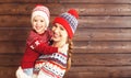 Happy family mother and child girl hugs at wooden background