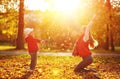 Happy family mother and child girl playing and throw leaves in a Royalty Free Stock Photo