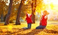 Happy family mother and child girl playing and throw leaves in a Royalty Free Stock Photo