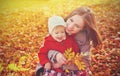 Happy family: mother and child little daughter play cuddling on autumn Royalty Free Stock Photo