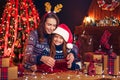 A happy family mother and child pack Christmas gifts