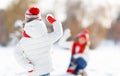 Happy family mother and child playing snowballs on winter walk