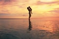 Happy Family. Mother And Child Silhouettes. Mom Kissing Daughter On Ocean Beach. Beautiful Sunset Sky And People Reflection. Royalty Free Stock Photo