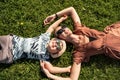 Happy family: mother and child son laughing, lying on the green grass in nature. Royalty Free Stock Photo