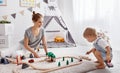 Happy family mother and child son playing in toy railway in pl Royalty Free Stock Photo