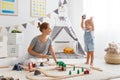 Happy family mother and child son playing in toy railway in pl Royalty Free Stock Photo