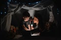 Happy family mother and child son reading a book with a flashlight in a tent at home. family concept Royalty Free Stock Photo