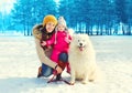 Happy family mother and child with white Samoyed dog walking in winter Royalty Free Stock Photo