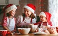 Happy family mother and children bake cookies for Christmas