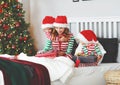 happy family mother and children in pajamas opening gifts on christmas morning near tree Royalty Free Stock Photo