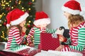 happy family mother and children in pajamas opening gifts on christmas morning near tree Royalty Free Stock Photo