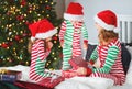 Happy family mother and children in pajamas opening gifts on christmas morning near christmas tree Royalty Free Stock Photo