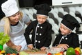 A family of cooks.Healthy eating. Happy family mother and children prepares vegetable salad in kitchen Royalty Free Stock Photo