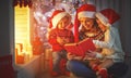 Family mother and children read a book at christmas near firep Royalty Free Stock Photo