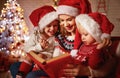 Family mother and children read a book at christmas near firep Royalty Free Stock Photo