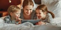 Happy family mother and children with tablet computer at home in bed in   evening Royalty Free Stock Photo