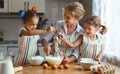 Happy family mother and children twins bake kneading dough in Royalty Free Stock Photo