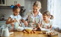 Happy family mother and children twins bake kneading dough in Royalty Free Stock Photo