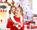 Happy family mother and daughter giving christmas gift